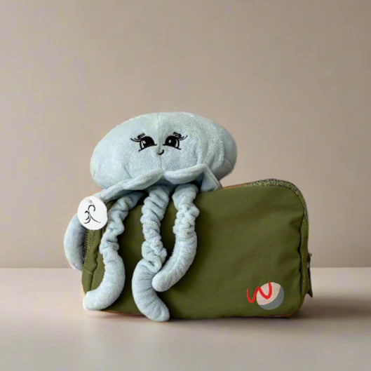 Plush weighted  jellyfish toy on a green bag with a beige background
