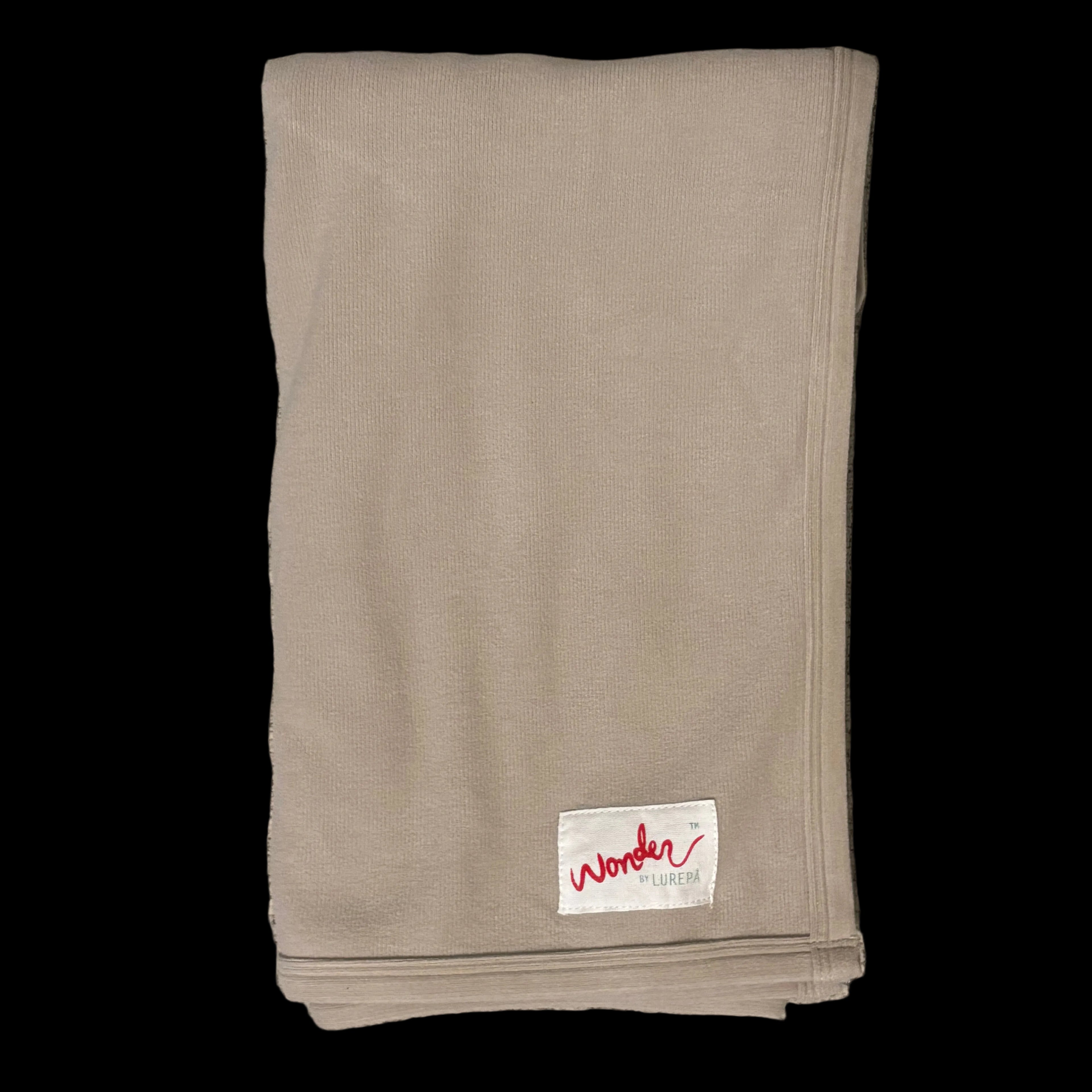 Folded beige ivory fabric with a label on a textured surface